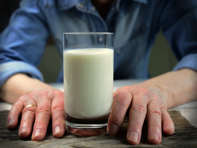 Hände mit einem Glas Milch