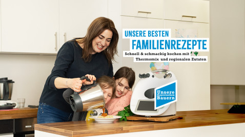 Frau mit Kinder steht am Thermomix