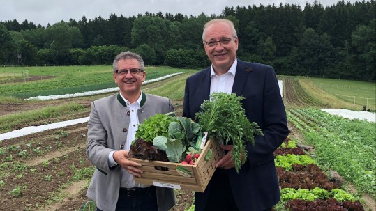 Herr Landrat Franz Löffler und Herr Andreas Brunner vom Verein "LandGenuss" halten eine Gemüsekiste